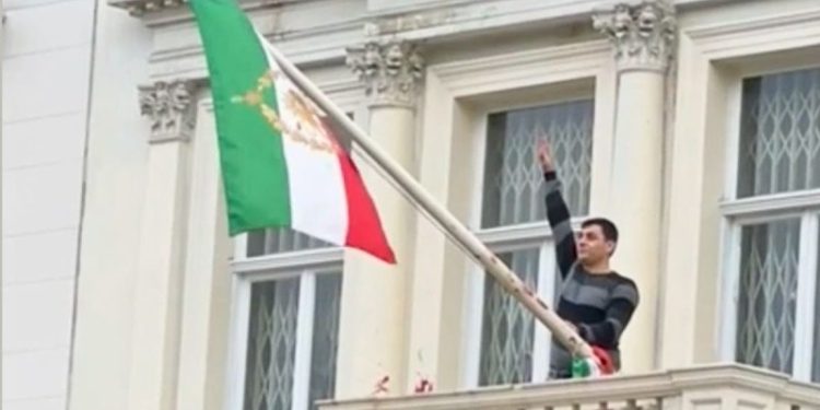 Protester scales Iranian Embassy in London, tears down regime flag, hoists pre-revolution symbol